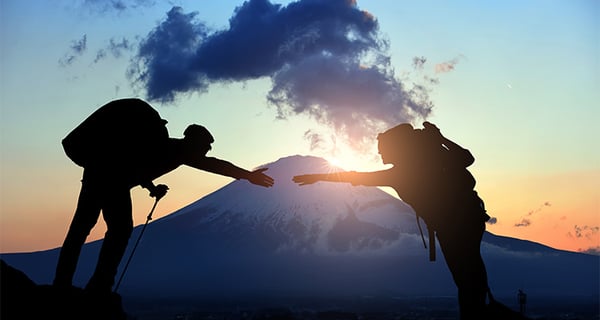 Men-Reaching-Over-Mountain-750x400